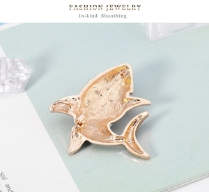 Detailed back view of a golden shark brooch showing the secure metal pin fastener