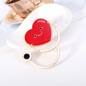 Broche créative en forme de stéthoscope cœur rouge avec visage souriant doré