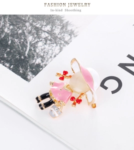 Détail d'une broche de petite fille en émail rose ornée d'une pierre œil-de-chat