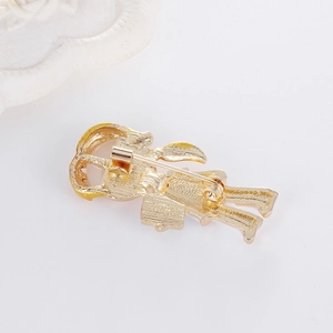 Detail of cartoon girl brooch back with gold alloy plating, pin fastener, and faux pearl