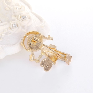 Back view of a gold alloy girl brooch with purple braid and umbrella details
