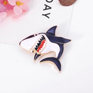 Cartoon enamel shark brooch with dark blue finish and gold metal trim on a white card