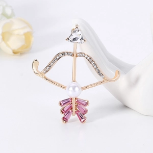 Elegant gold bow and arrow brooch with pink crystal feathers and a white pearl accent