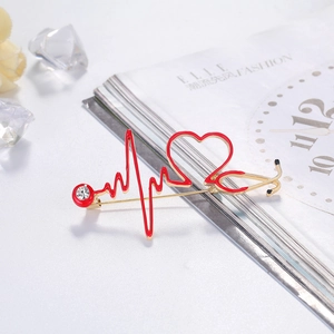 Golden stethoscope and red EKG heart rate medical brooch with elegant rhinestone accent