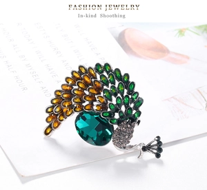 Détail de la broche paon avec cristal émeraude et finition en émail vert brillant