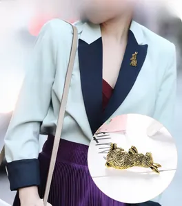 Detail of vintage gold rabbit brooch with textured fur on a light blue blazer lapel