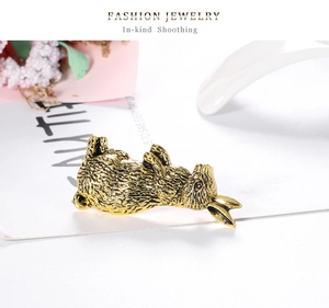 Detailed close-up of a vintage golden rabbit brooch with textured antique finish