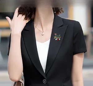 Christmas sleigh brooch with enamel charms on black suit jacket shown on model