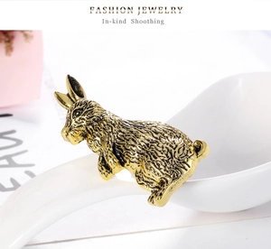 Macro shot of vintage gold rabbit brooch detailing fine textured fur and antique alloy finish