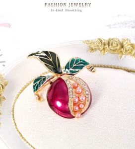 Detail der Granatapfel-Brosche mit rosa Perlenimitaten und Strasssteinen auf Goldbasis