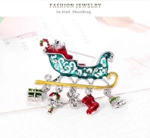 Detail of Christmas sleigh brooch with enamel charms like deer and bells in macro view