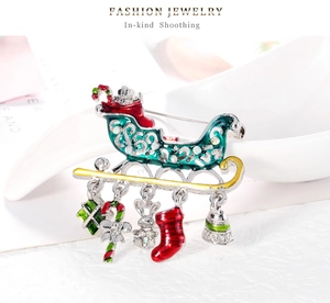 Detail of Christmas sleigh brooch with rhinestones and enamel holiday charms