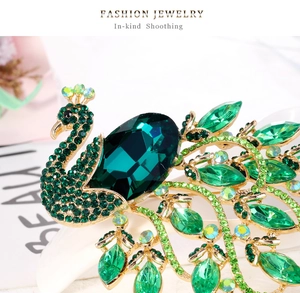 Macro detail of a vintage peacock brooch with green crystals and gold-tone alloy plating