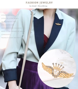 Détail d'une broche couronne ailes d'ange vintage avec perles et cristaux sur un blazer