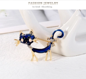 Détail macro d'une broche chat en émail bleu avec strass blancs sur métal doré