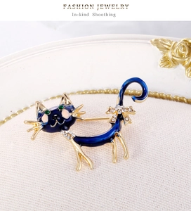 Gros plan de la broche chat en émail bleu avec strass sur un fond vintage élégant