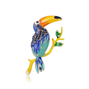 Elegant toucan bird brooch with colorful enamel gradient and blue gemstone accents