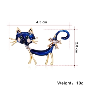 Broche chat en émail bleu avec nœud en strass et métal doré sur fond blanc pur