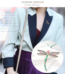 Detail of dragonfly brooch featuring emerald green gems and sparkling rhinestones
