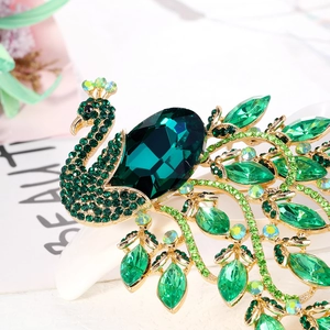Vintage green peacock brooch with alloy crystal rhinestones shown on a beauty magazine