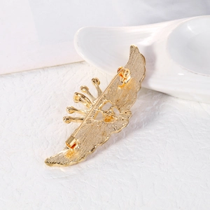 Broche couronne ailée dorée vue de dos avec texture métallique et épingle de sûreté