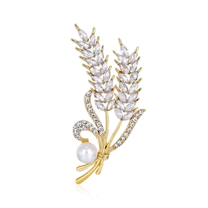 Elegant wheat stalk brooch with sparkling rhinestones and a white pearl on white background