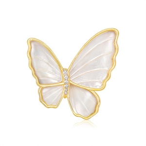 Détail de broche papillon en or élégante avec ailes en nacre et cristaux de zircon