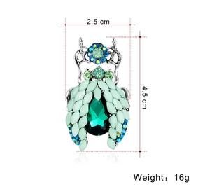Detail view of beetle brooch showing mint green gemstones and 4.5 cm dimensions