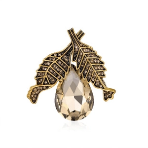 Detail view of a vintage butterfly brooch featuring amber rhinestones and a pear-cut crystal