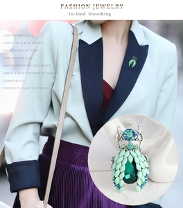 Close-up of a green beetle brooch with rhinestones worn on a blue blazer lapel
