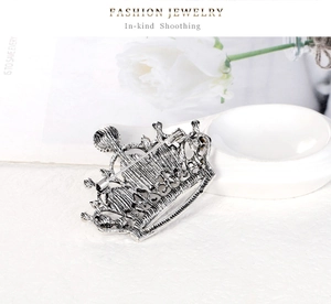 Macro shot of crown brooch back side with antique silver finish and safety pin clasp