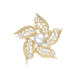Macro shot of crown star brooch featuring large central pearl and golden leaf arms with tiny pearls