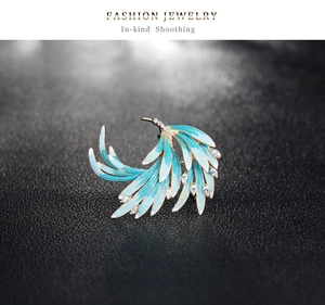 Close-up of elegant phoenix feather brooch with blue enamel and sparkling crystals