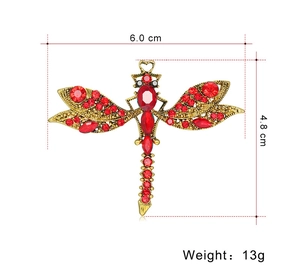 Detailed view of vintage dragonfly brooch with red rhinestones and 6.0cm by 4.8cm dimensions