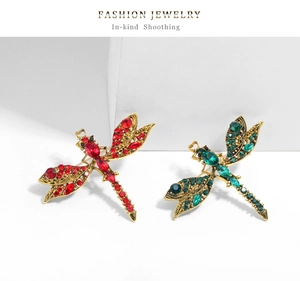 Macro shot of vintage dragonfly brooches featuring colorful gemstones and crystal wings