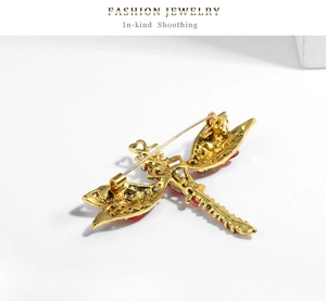 Detail view showing the golden back structure and secure pin of the dragonfly brooch