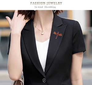Vintage dragonfly brooch with red rhinestones pinned on a black suit lapel for styling