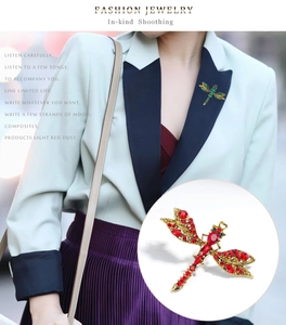Close-up of vintage dragonfly brooches featuring red and green crystal rhinestones