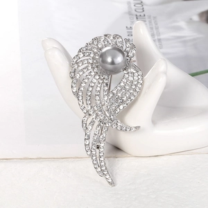Élégante broche ailes argentées avec strass brillants et une grande perle grise