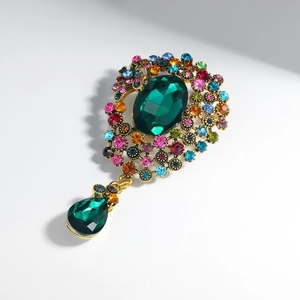 Broche dorée vintage avec émeraude centrale et cristaux multicolores en forme de goutte