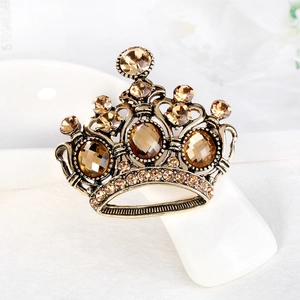 Spilla a corona vintage dorata con strass ambra su supporto da esposizione