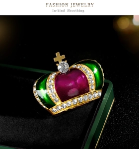 Dettaglio della spilla a corona vintage con smalto verde e strass nella scatola