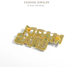 Detail view showing star-patterned gold alloy pin back with sturdy clasp and MARDI GRAS text