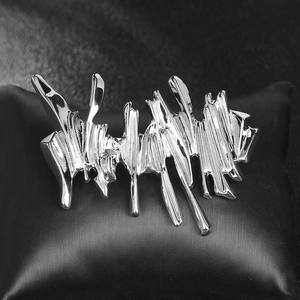 Irregular liquid metal silver brooch with a molten drop design on black display background
