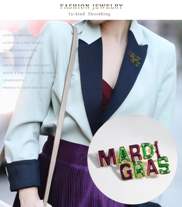 Detailed view of Mardi Gras enamel brooch with rhinestones worn on a stylish suit lapel