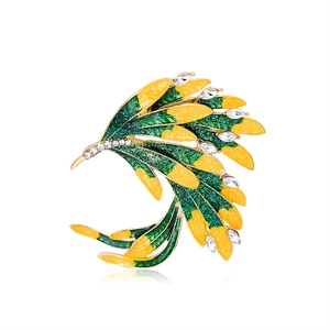 Elegant phoenix brooch with gold finish, green enamel wings and sparkling rhinestones