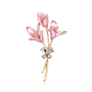 Élégante broche lys dorée avec trois fleurs roses et accents en cristal goutte