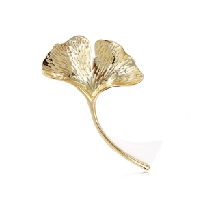 Elegant gold ginkgo leaf brooch with detailed veins and metallic luster on white background