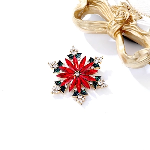 Détails de broche flocon de Noël avec cristaux rouges et touches d'émail vert