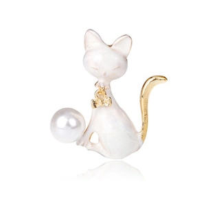 Dettaglio di una spilla a gatto con fiocco dorato, smalto bianco e grande perla lucida